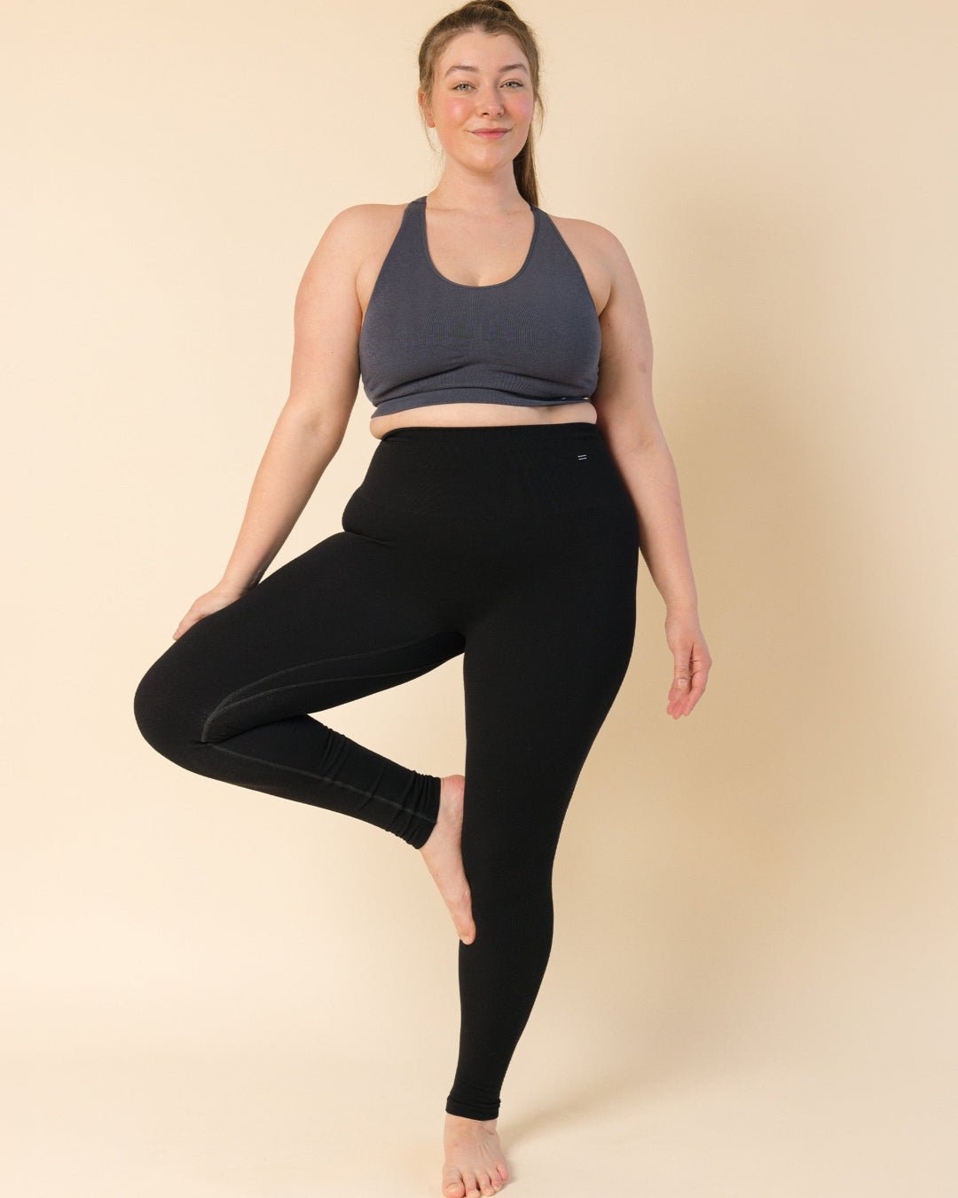 Woman posing in grey racerback bra and Black Merino leggings