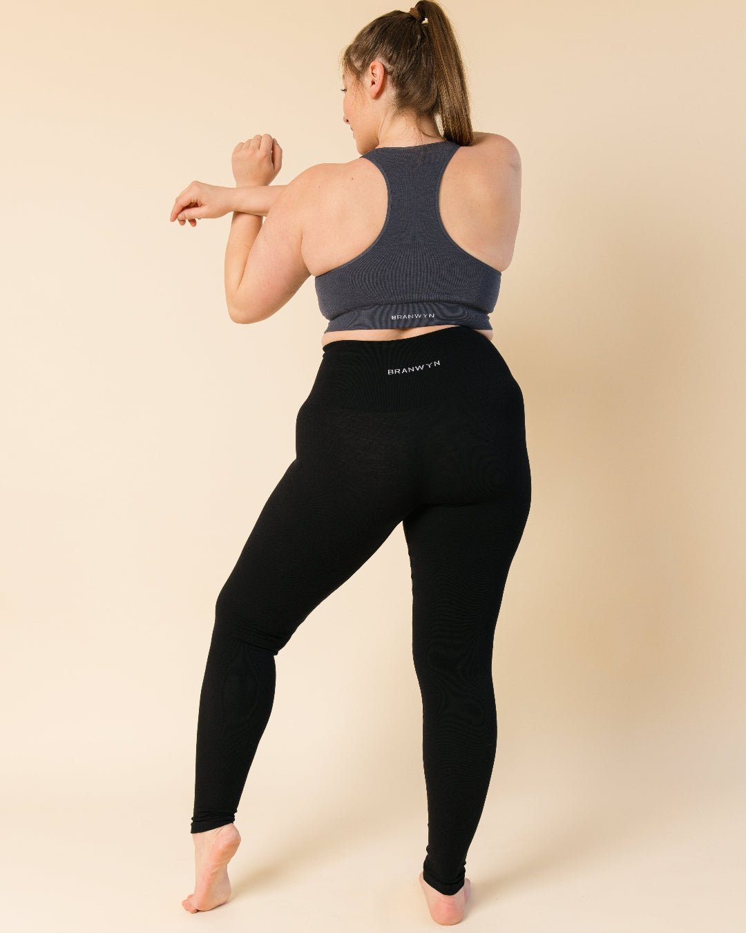 “Back view of woman in Merino wool thermal leggings, versatile for running, gym workouts, and yoga