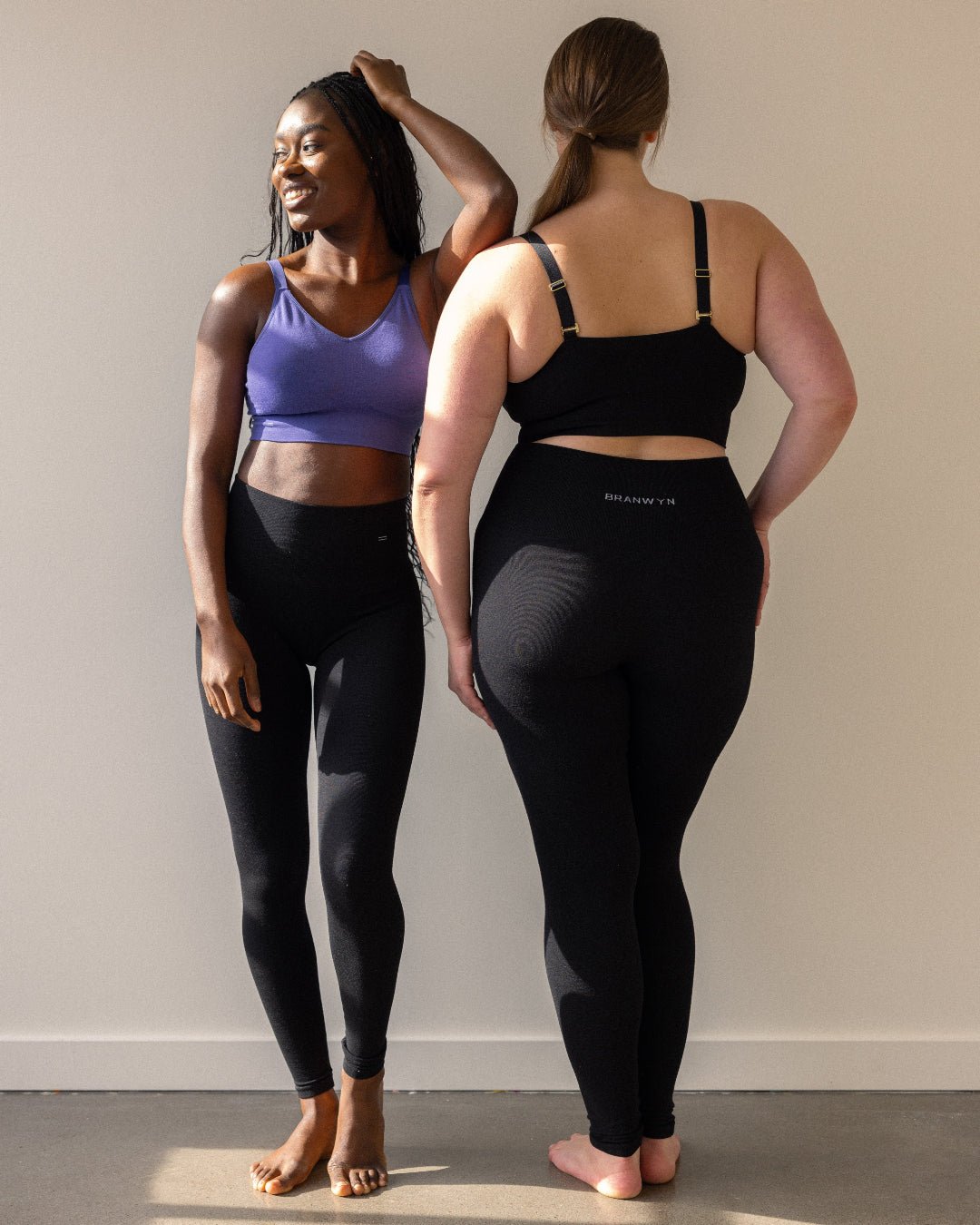 Two women posing in bras and wearing full length compression leggings by BRANWYN.