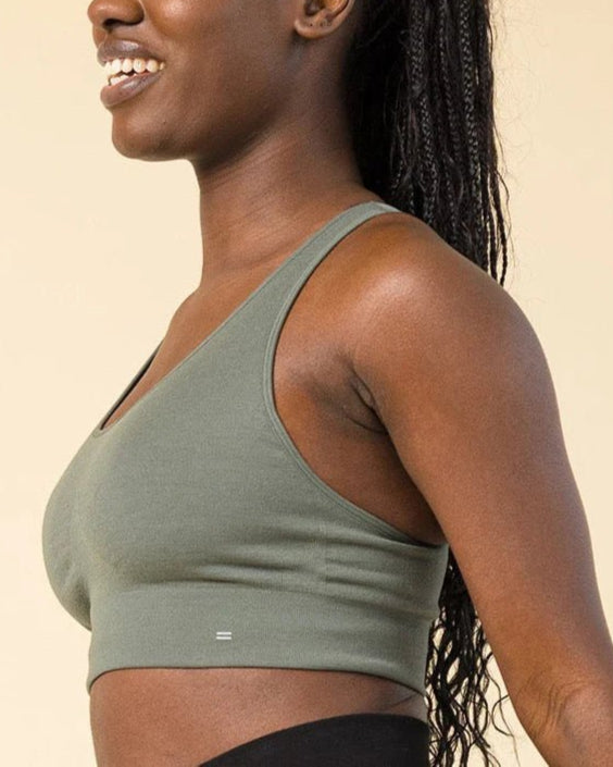 Side view of BRANWYN Racerback Sports Bra in green. Eco-friendly Merino bra made for hiking and gym with lightweight, odor-resistant comfort.