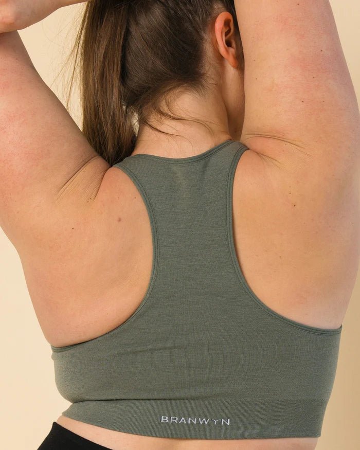 Back view of BRANWYN Racerback Sports Bra in green. Seamless Merino wool provides compressive, breathable support without rubbing or chafe.