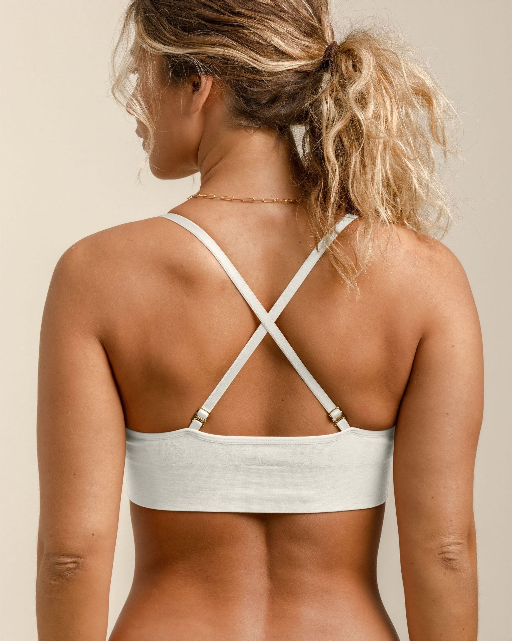 Back view of BRANWYN Essential Bralette in Natural White, adjustable straps crossed for extra support.