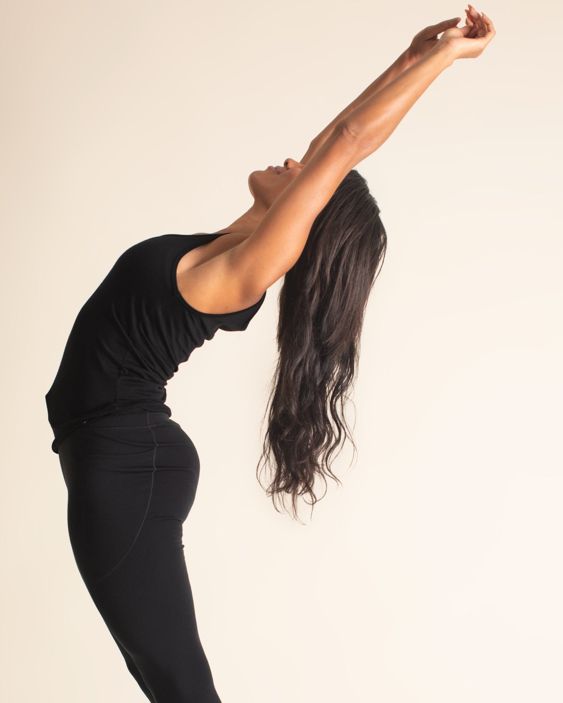 Woman wearing a BRANWYN Women's Merino Wool Natural Black Tank and Women's Merino wool Black leggings doing yoga