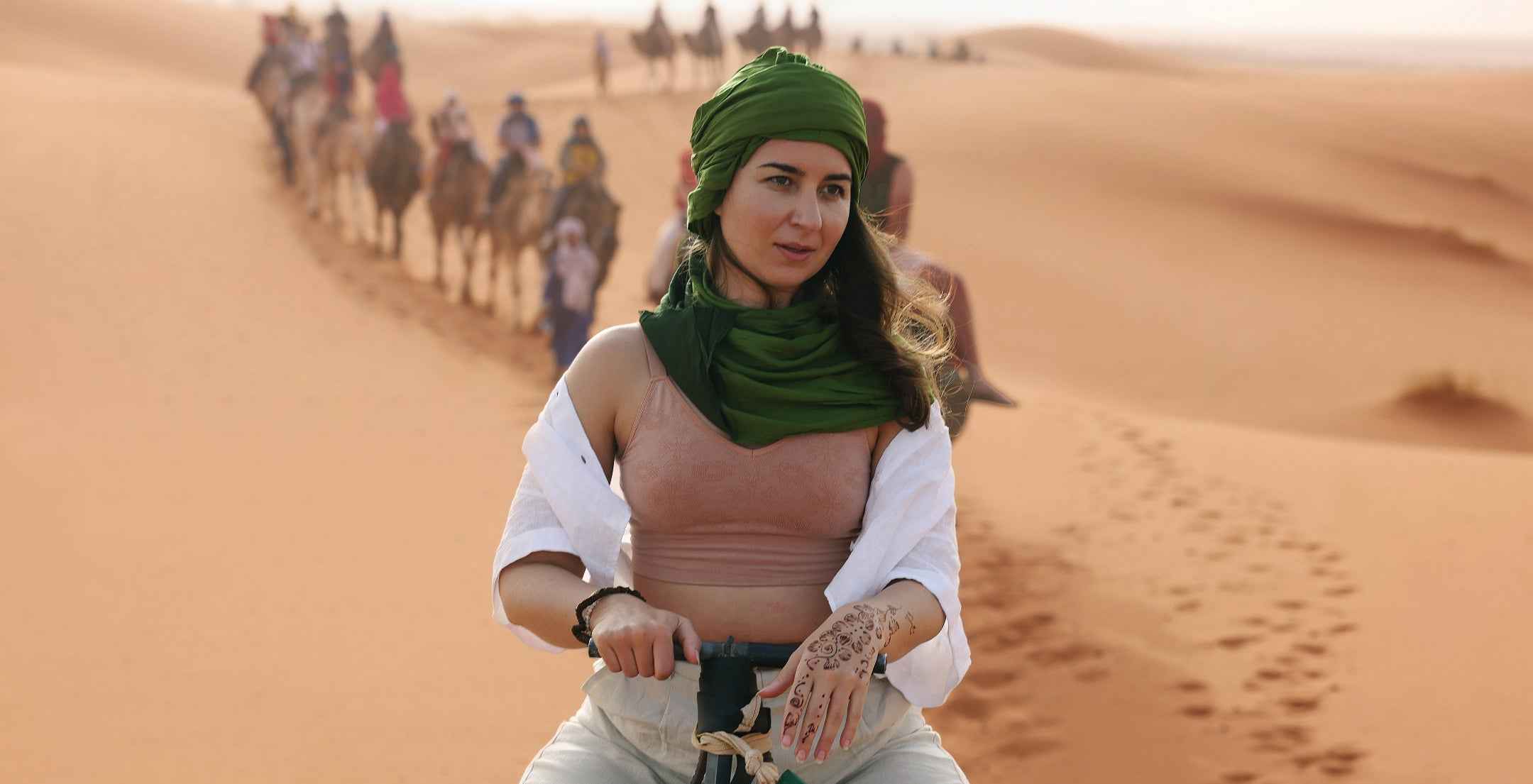 Woman traveling solo in Morocco. She is riding a camel wearing BRANWYN Merino wool bras and underwear