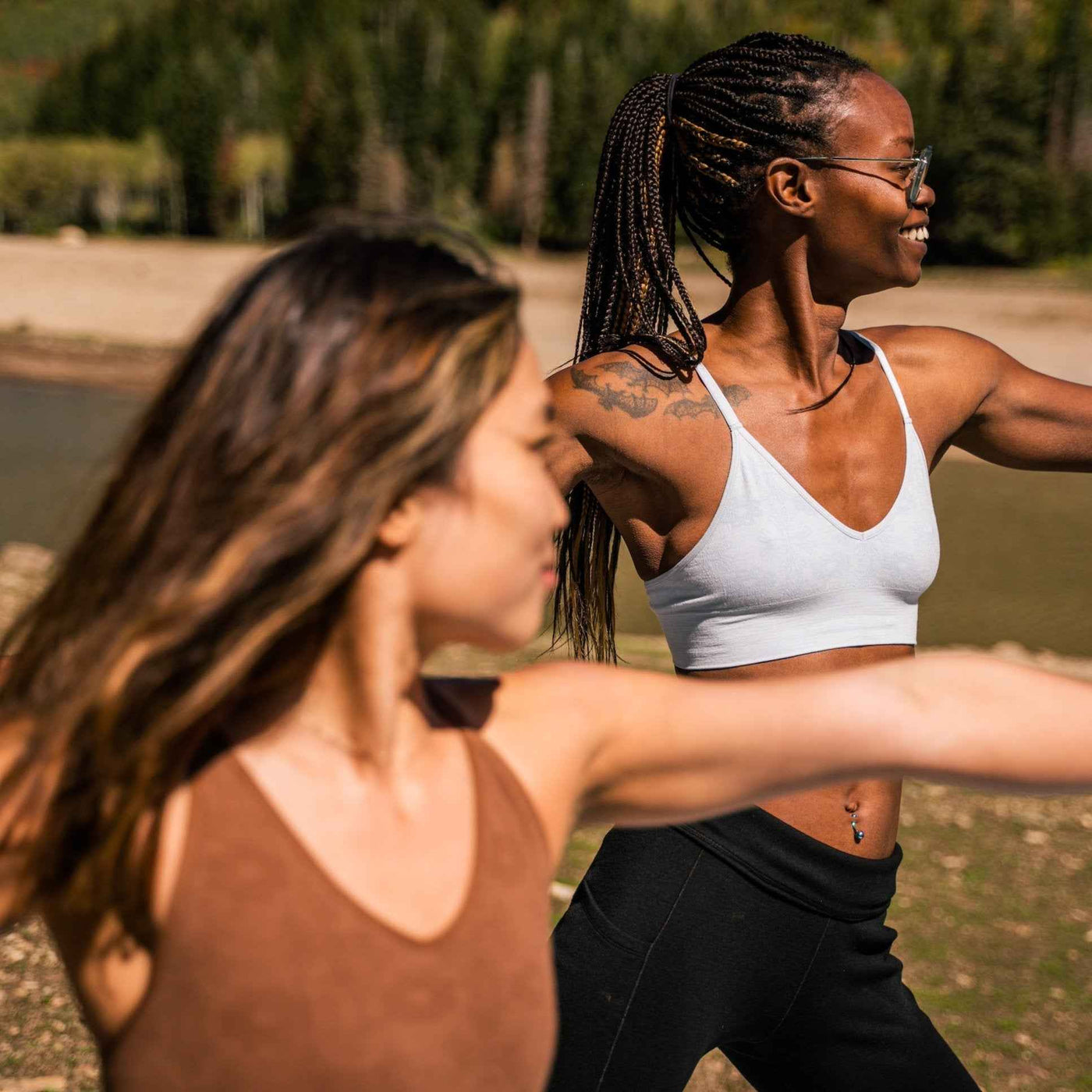 Two women doing yoga in the mountains wearing BRANWYN performance innerwear Luna Gray Bralette