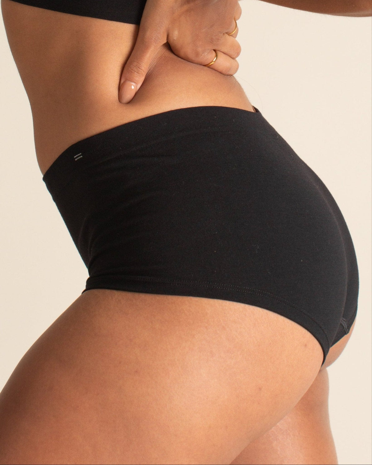 Side profile of woman wearing BRANWYN Essential Boyshort seamless Merino Underwear in black.