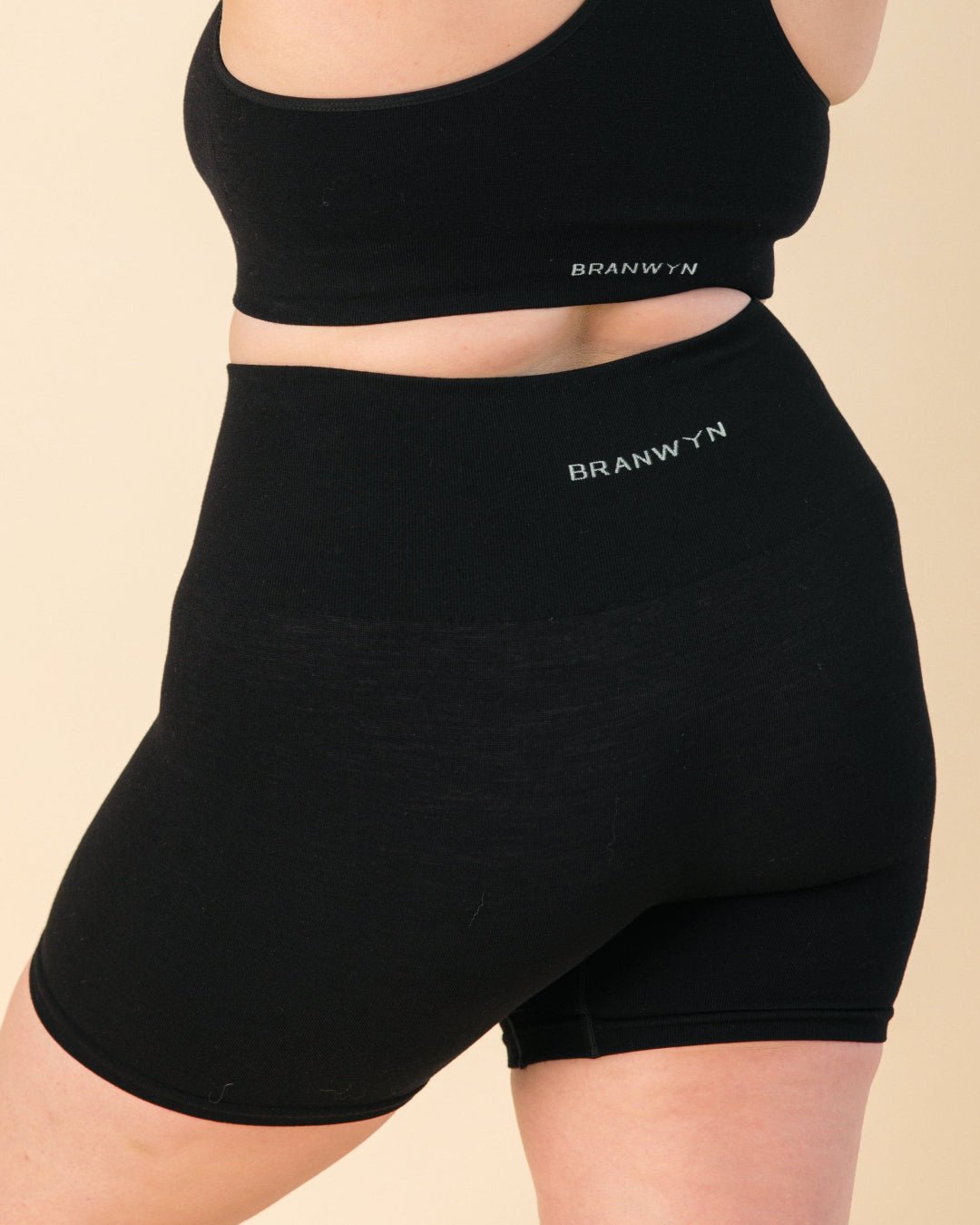Model wearing black Essential Compressive Short in black, a Merino wool compression short.