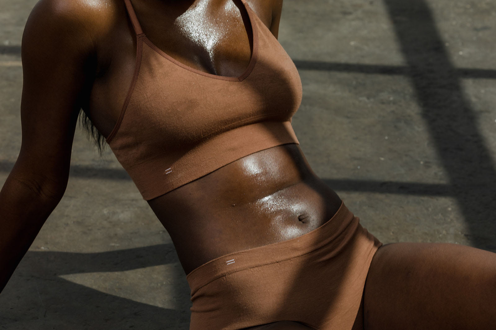 Woman sweating in BRANWYN seamless Merino wool bralette and hipster dark nude