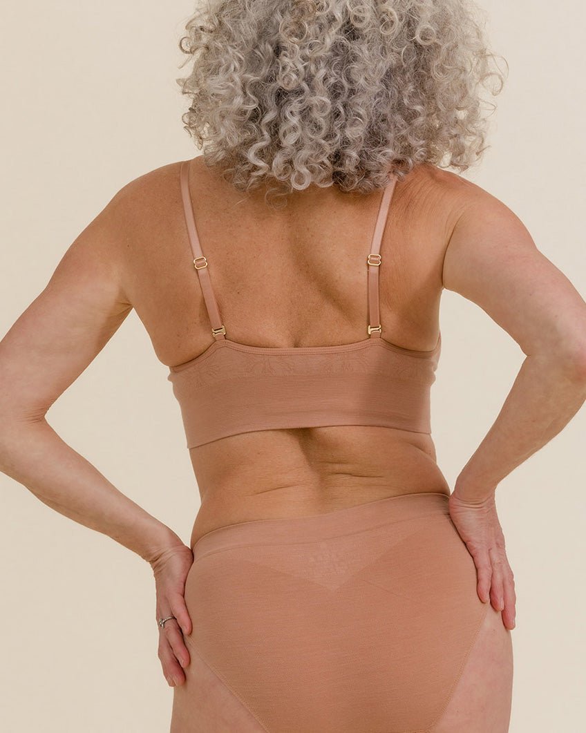Back view of woman wearing BRANWYN Essential Bralette in Warm Nude with matching Merino underwear.