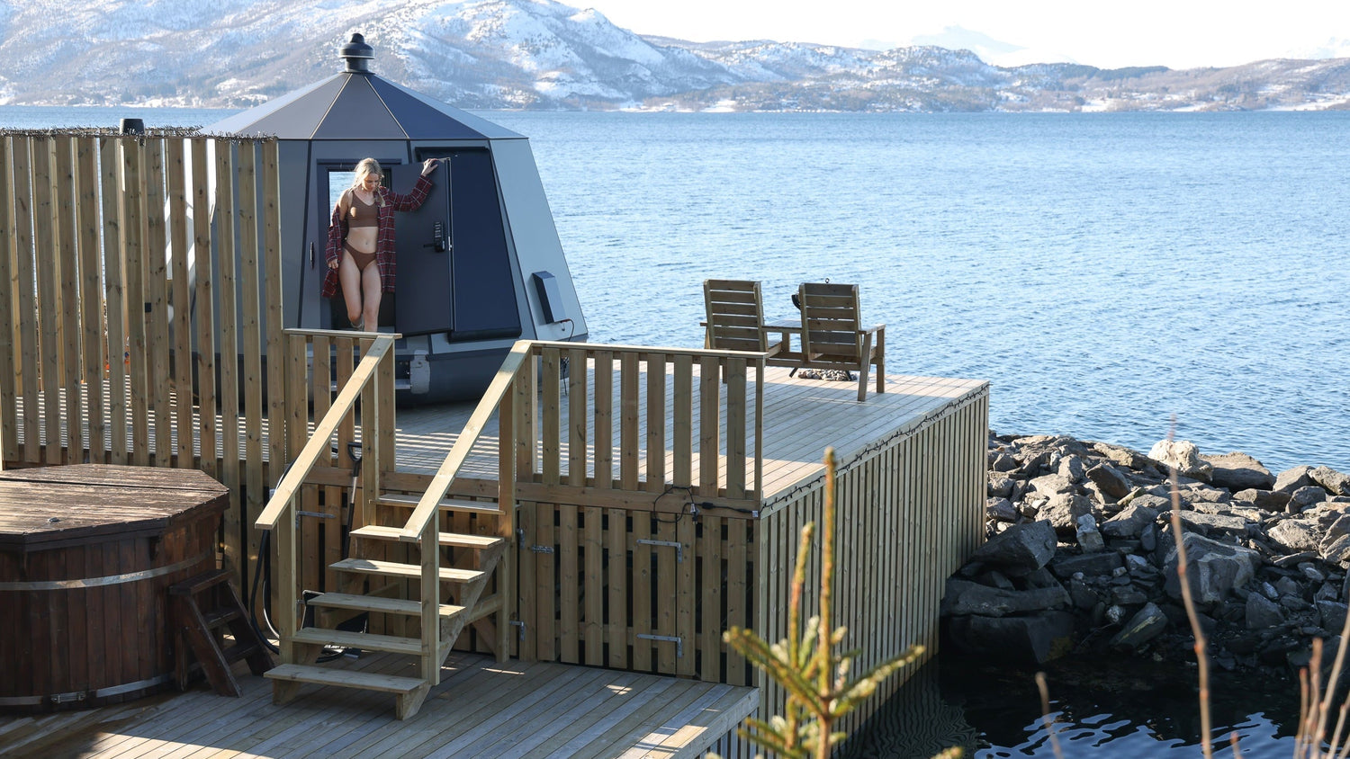 Women standing in the doorway of a lakeside cozy cabin.