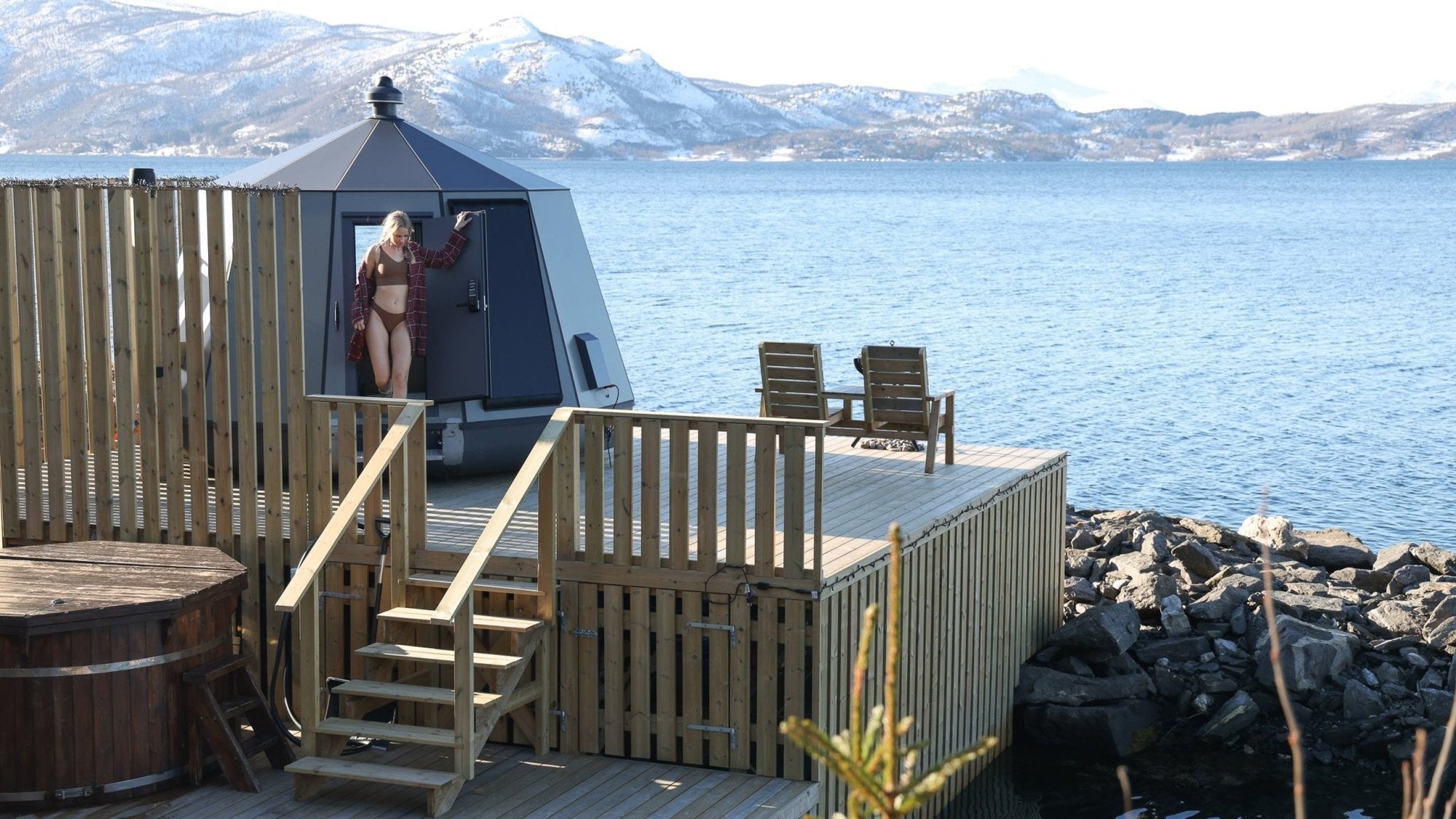 Woman in remote modern cabin on a lake in the winter, photographed by travel photographer Lane Oliveri.