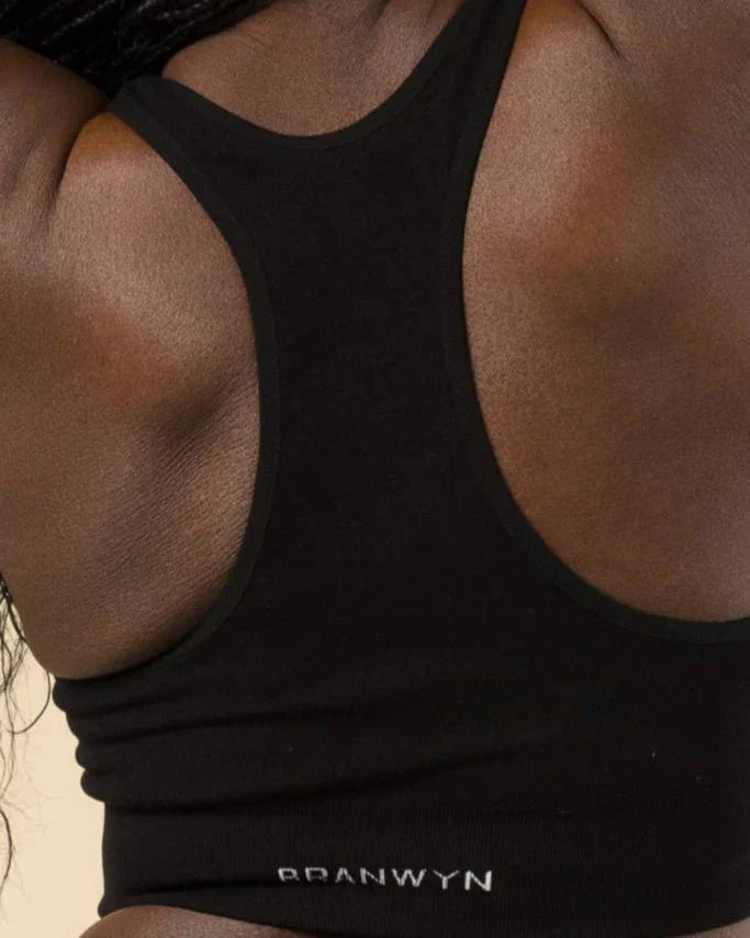Close-up detail of racerback design on BRANWYN Sports Bra in black. Seamless Merino wool provides compressive, breathable support.