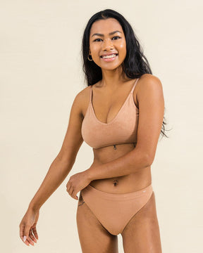 Woman in Merino warm nude underwear set from BRANWYN. The women's Essential Bikini is perfect for hiking, yoga, and gym sessions with moisture wicking comfort.