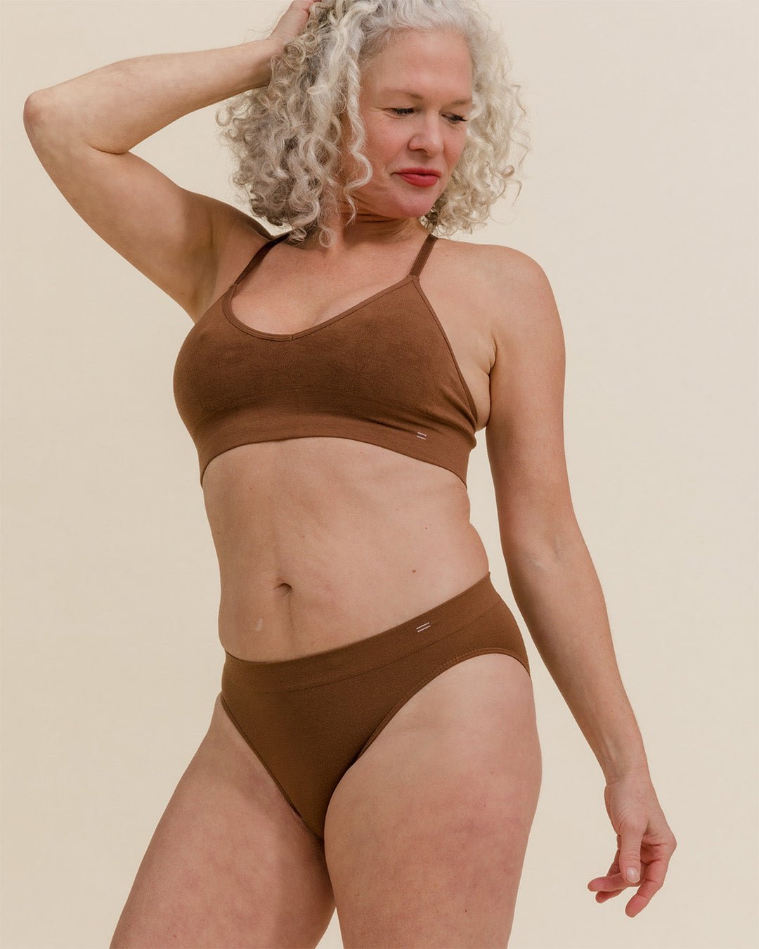 Woman posing in dark nude brown Merino underwear set, wearing BRANWYN Essential Bikini underwear made from soft, moisture wicking natural fibers.