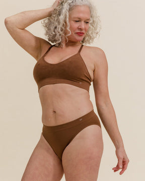 Woman posing in dark nude brown Merino underwear set, wearing BRANWYN Essential Bikini underwear made from soft, moisture wicking natural fibers.