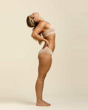 Woman stretching in Merino wool athletic underwear by BRANWYN, sweat wicking and temperature regulating comfort no matter the movement.