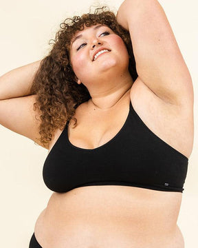 Woman standing in BRANWYN Essential Merino bralette and underwear set, seamless natural fiber innerwear.