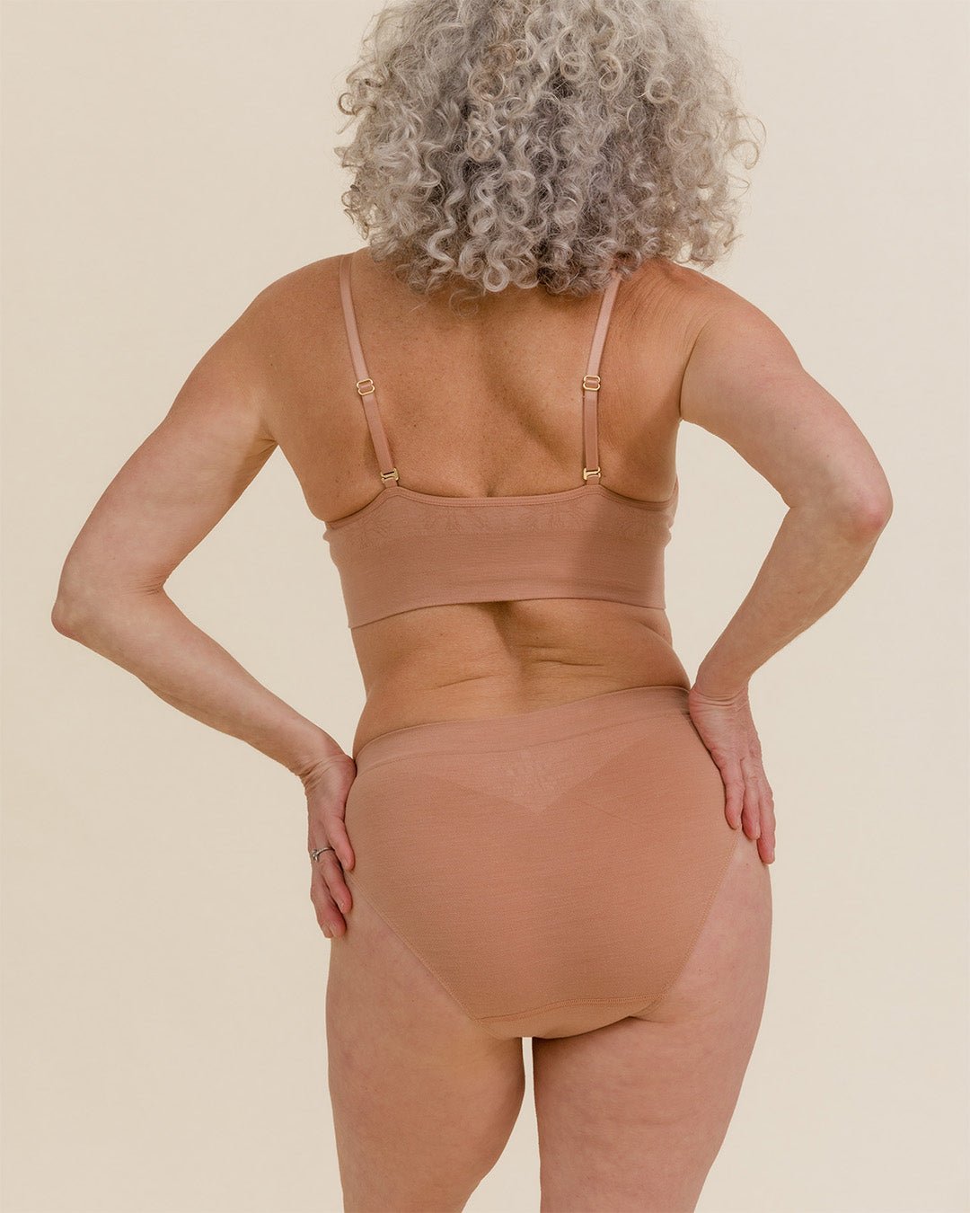 Back view of woman wearing BRANWYN Essential Merino wool underwear in light nude with matching Merino bra.