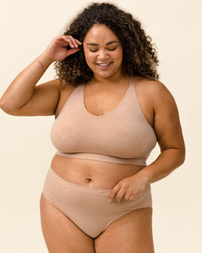 Woman smiling in Merino underwear and bra set. Wearing the Essential Hipster, BRANWYN underwear made of sustainable Merino wool natural fibers.