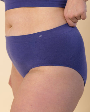 Woman wearing BRANWYN's Essential Hipster, a underwear from the Essential Collection. Made from soft, moisture-wicking Merino wool using seamless technology, this performance innerwear provides performance, comfort, and sustainability. The fabric is free from BPA, PFAS, and forever chemicals.