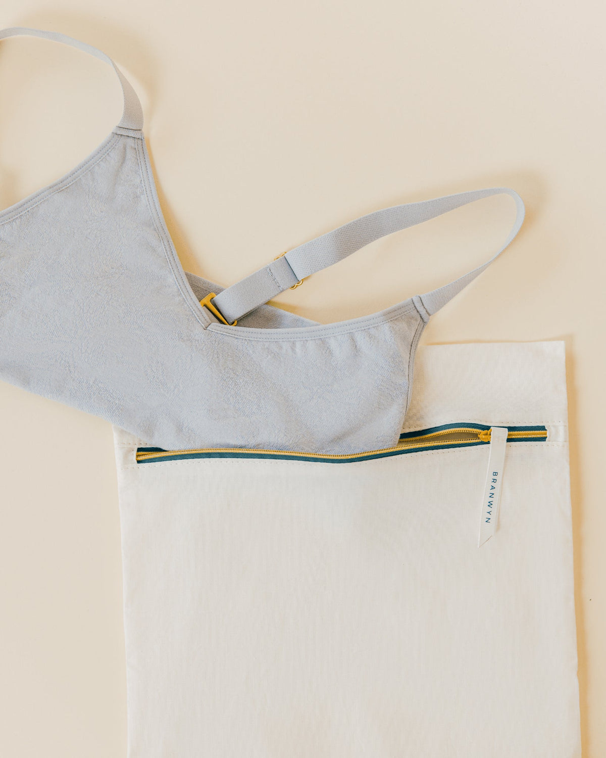 Image shows BRANWYN's Essential Laundry Bag, a GOTS Certified Organic cotton wash bag designed to protect bras and underwear during machine washing. Made from eco-friendly, non-synthetic fabric, it helps prevent snagging, stretching, and damage—prolonging the life of your essentials. Unlike synthetic mesh bags, this organic cotton alternative prevents microplastic pollution, supporting both environmental and social responsibility. A sustainable choice for garment care.