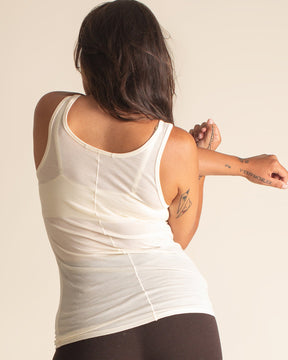 Woman wearing a BRANWYN Women's Merino Wool Natural White Tank and Seamless Merino Women's Compressive Leggings in Deep Mocha Brown