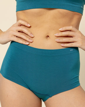 Front view of a model wearing BRANWYN Sustainable Seamless Merino Wool Essential Boyshort in Transformative Teal.