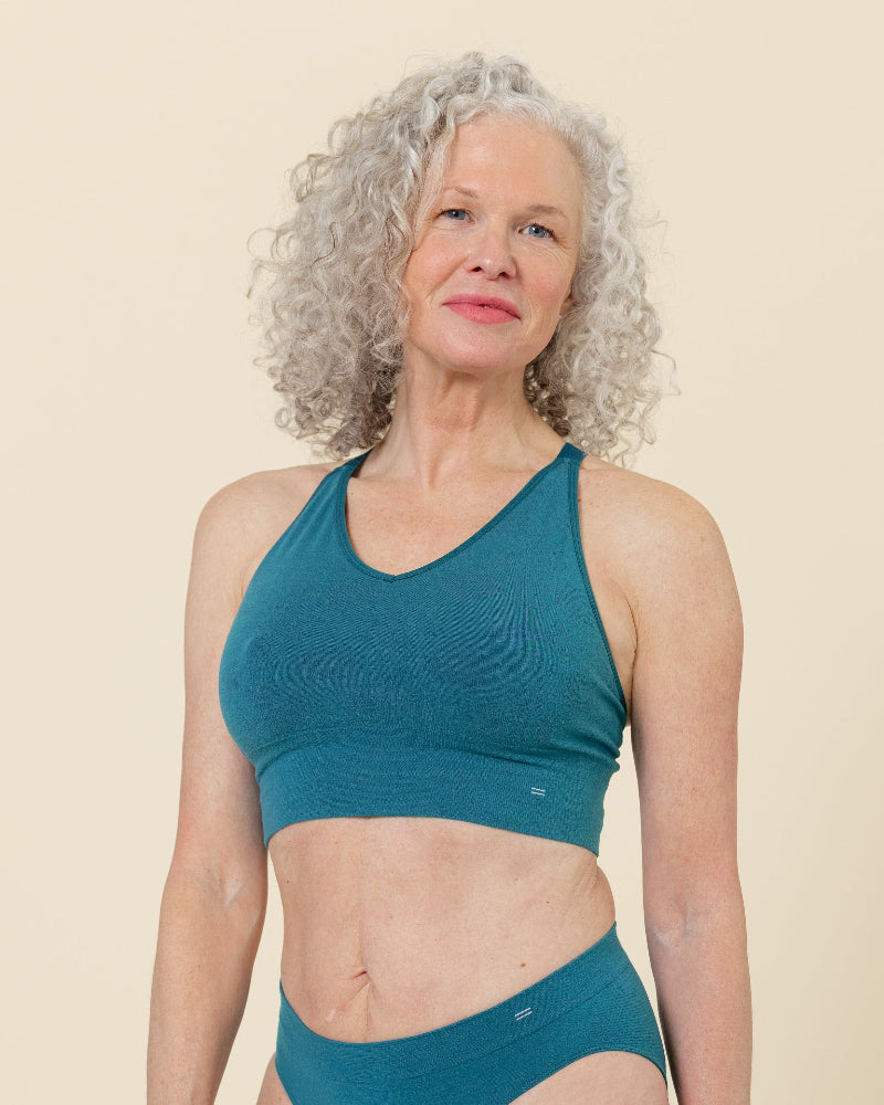 Front view of a model wearing BRANWYN Natural fiber Seamless Merino Wool Essential Busty Bra in Transformative Teal.