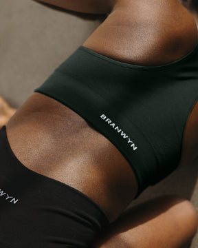 BRANWYN Essential Seamless Merino Wool Racerback Sports Bra in Deep Willow Back View on a Model Doing Yoga Back View