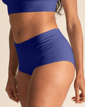 Woman wearing a BRANWYN Merino wool seamless future dusk boyshort set against a beige background.