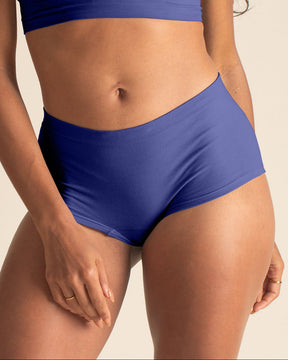 Woman wearing a BRANWYN Merino wool seamless future dusk boyshort set against a beige background.
