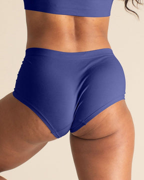Woman wearing a BRANWYN Merino wool seamless future dusk boyshort set against a beige background.