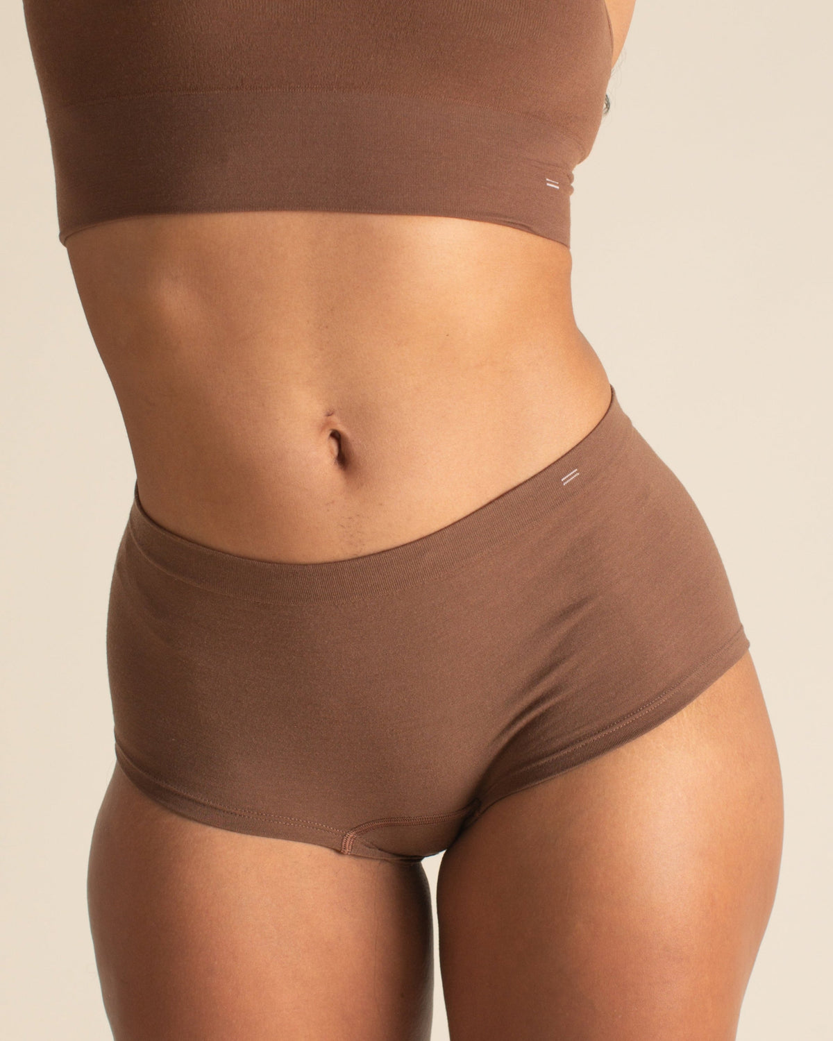  woman wearing BRAWNYN women's seamless Merino wool Boyshorts underwear and Busty Bra in Dark Nude. Great for skiing, winter sports, swimming, best hiking underwear, and travel.