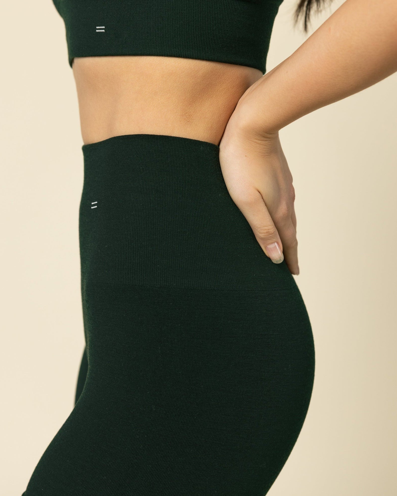 Person wearing a green sports bra and seameless Merino wool shorts
