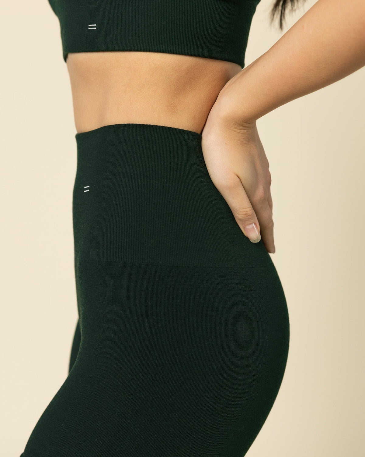 Person wearing a green sports bra and seameless Merino wool shorts