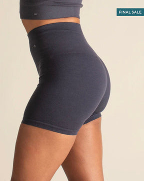 Person wearing a dark blue athletic outfit on a beige background