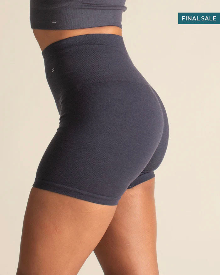Person wearing a dark blue athletic outfit on a beige background