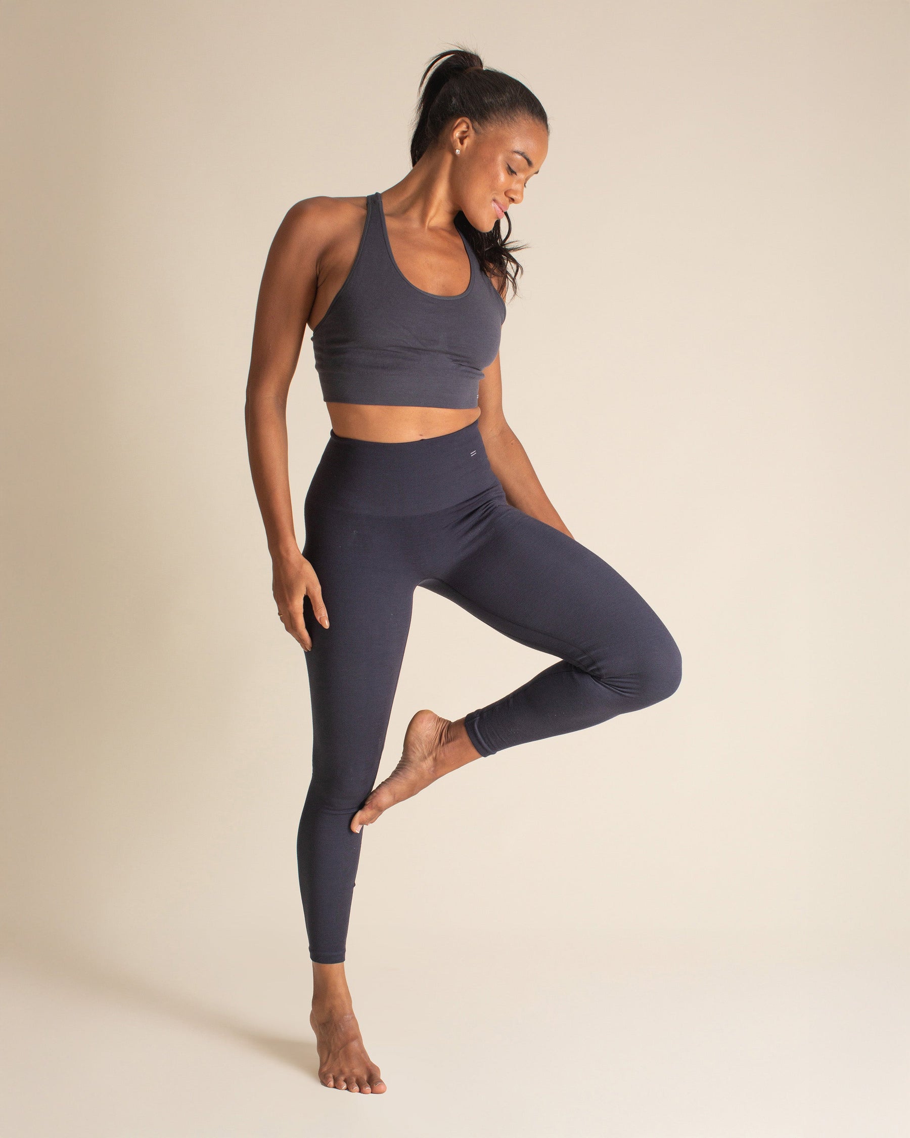 Woman posing in grey Merino wool bra and blue Merino wool leggings. Nontoxic activewear that is both breathable and forever chemical free.