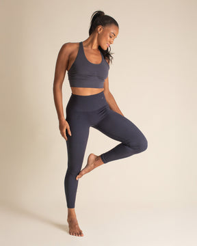 Woman posing in grey Merino wool bra and blue Merino wool leggings. Nontoxic activewear that is both breathable and forever chemical free.