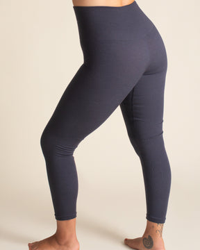 Navy leggings worn by a person on a beige background