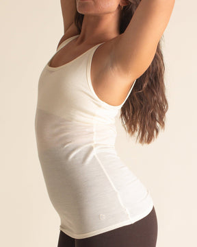 Side view of Kiki is wearing a BRANWYN women's Merino wool classic tank top, size medium, with a hip-length design in Natural White. Perfect for Yoga.