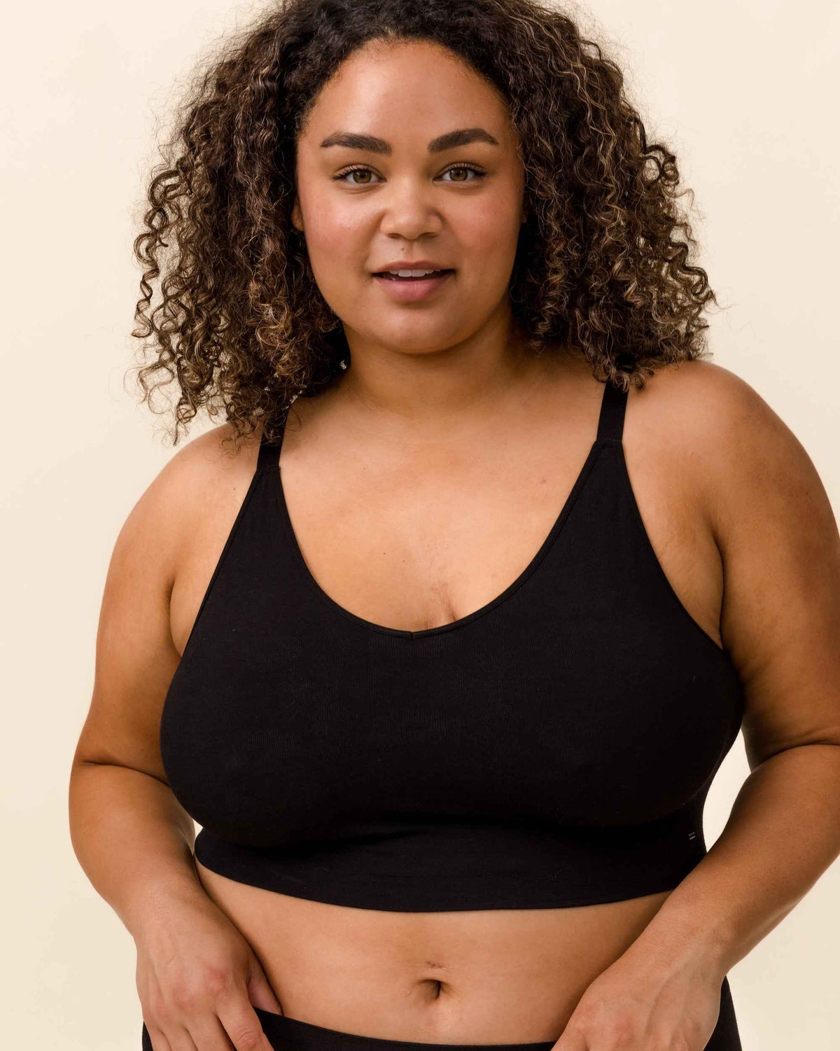 Woman wearing black Merino BRANWYN bra for breast pain related to hormones, menopause, or mastectomy.