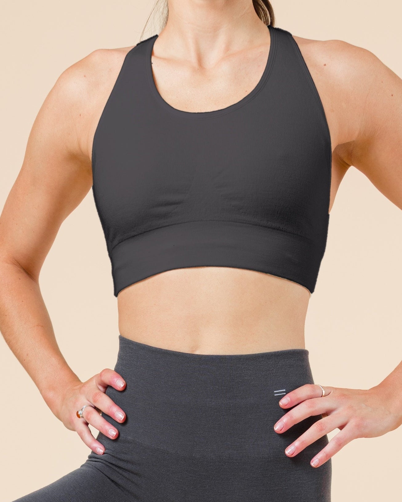 BRANWYN seamless Merino wool Racerback Sports Bra in Slate, front view in a tree pose, worn with matching Slate compressive leggings