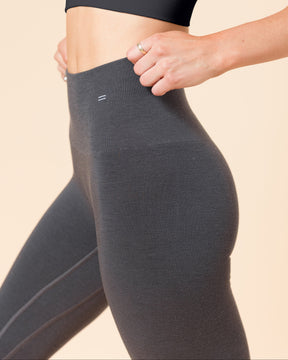 Woman in the BRANWYN Merino wool Racerback Sports Bra and compressive leggings in Slate, side profile