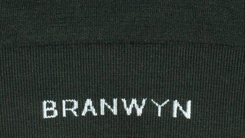Close-up of a black garment with 'BRANWYN' embroidered on it.