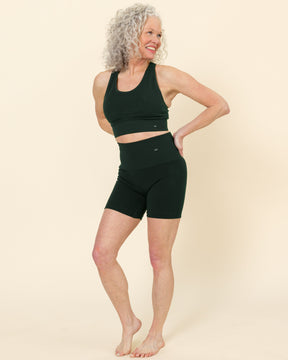 The model is wearing BRANWYN’s seamless compressive shorts in Deep Willow—Merino wool bike shorts with a 6-inch inseam, perfect for hiking, yoga, and gym workouts.