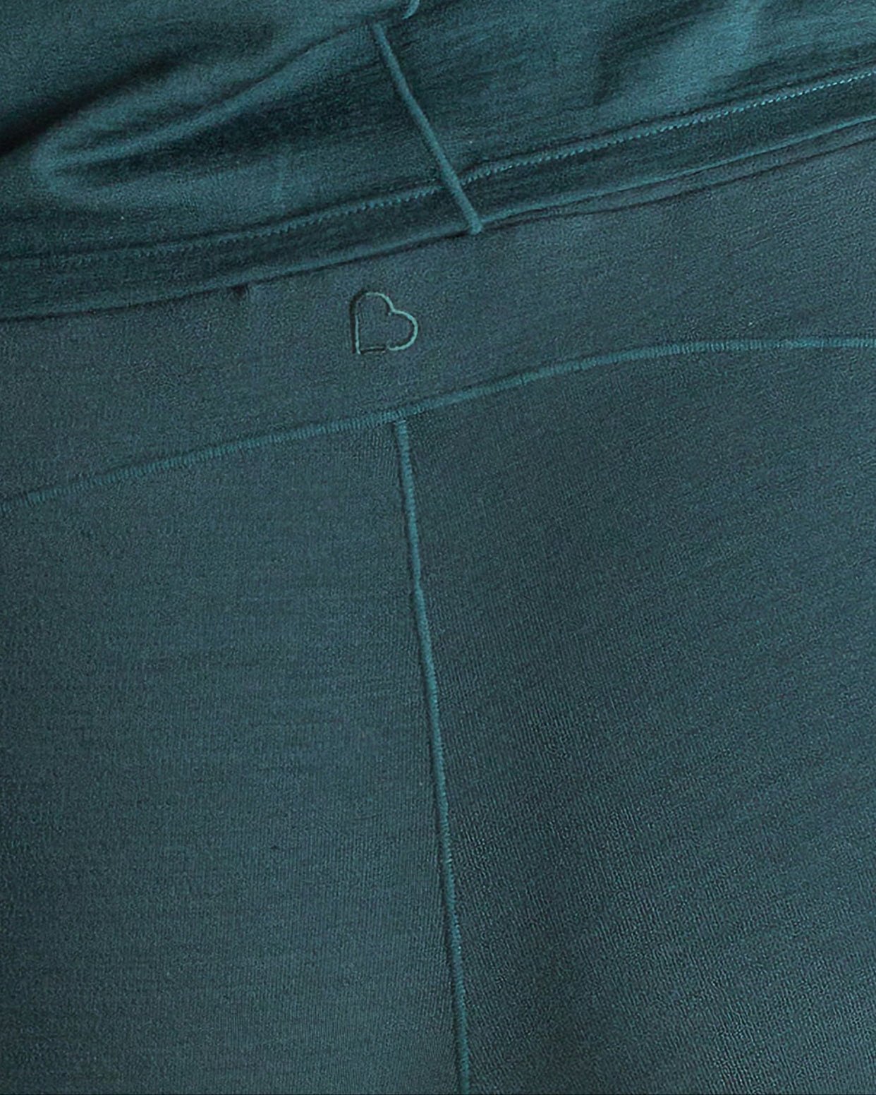 Close-up detail of teal BRANWYN Merino wool jogger sweatpants with embroidered heart logo. Made of 85% sustainable, regenerative Merino wool fibers.