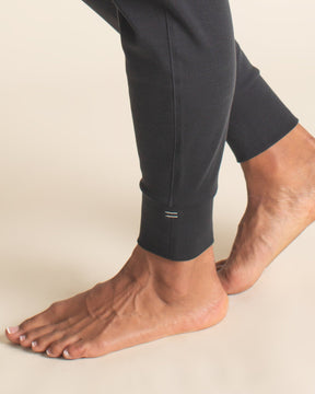 Detail of black Merino wool jogger ankle cuff with embroidered BRANWYN equal sign logo.