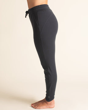 Side view of BRANWYN black Merino joggers with drawstring waistband. Women’s tapered sweatpants made of super soft natural Merino wool fibers.