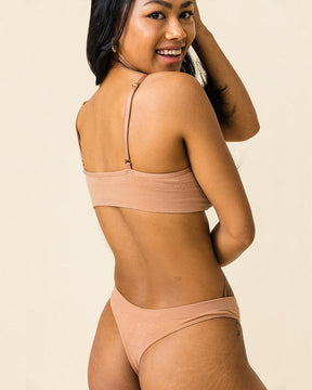 Woman wearing BRANWYN's Essential Bralette, a bra from the Essential Collection. Made from soft, moisture-wicking Merino wool using seamless technology, this performance innerwear provides performance, comfort, and sustainability. The fabric is free from BPA, PFAS, and forever chemicals.